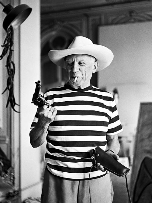 Picasso with the revolver and hat gifted by Gary Cooper, 1958